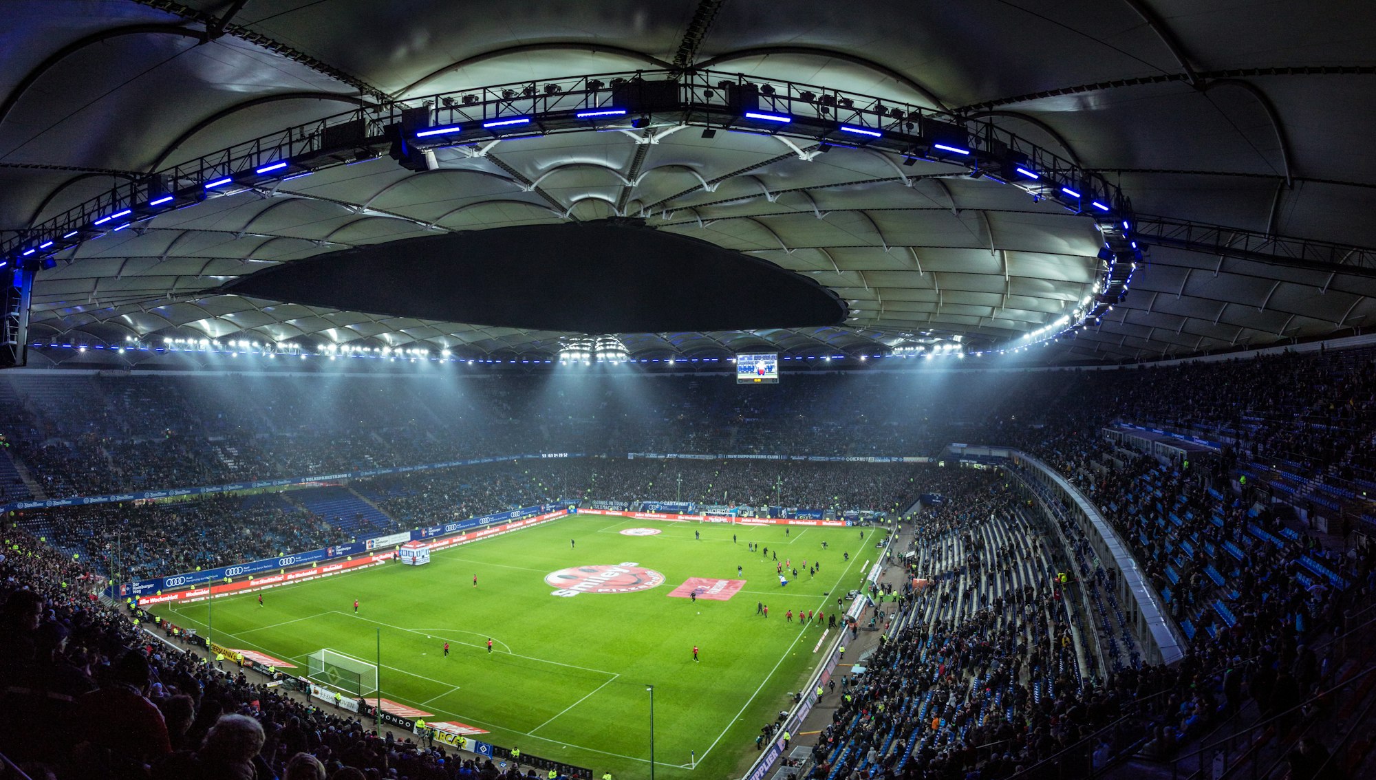 A packed stadium under floodlights on match night